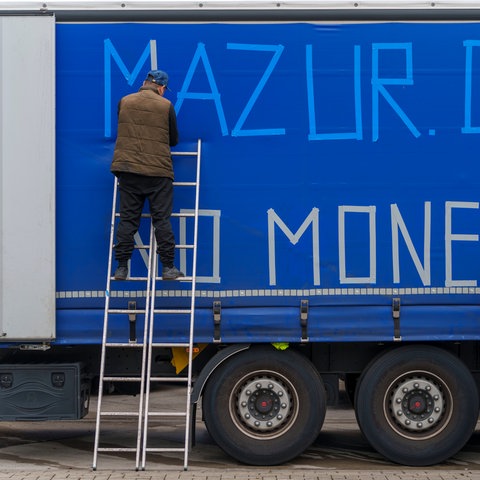 Streikende LKW-Fahrer bekleben die Außenplane eines Fahrzeuges "Mazur Debtor - No Money", um auf ihre Situation aufmerksam zu machen. 