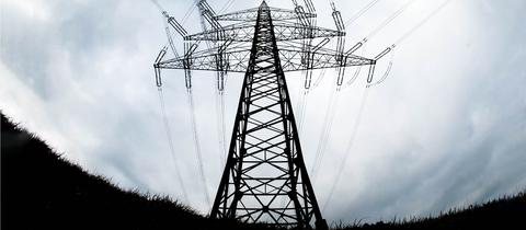 Ein mächtiger Strommast aus der Froschperspektive und im Gegenlicht fotografiert.