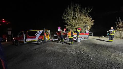 Nächtliche Szene mit Feuerwehrkräften im Einsatz.
