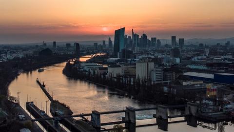 Die Sonne geht über der Skyline von Frankfurt unter.
