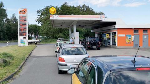 Eine Tankstelle mit vielen Autos aufgereiht. 