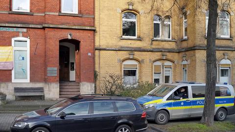 Außenansicht eines Mehrfamilienhauses von der Straße aus. Vor dem Eingang des roten Backsteinaltbaus steht ein Polizeiauto. Neben dem Eingang ein Schild einer Frauencomputerschule.