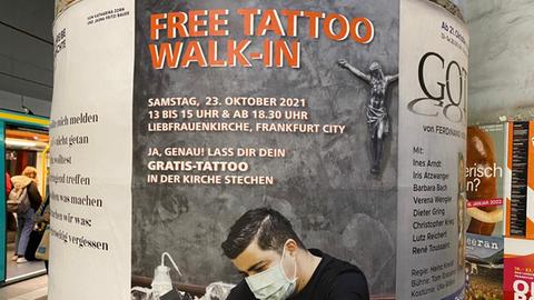 Werbeplakat, auf dem ein Tätowierer zu sehen ist