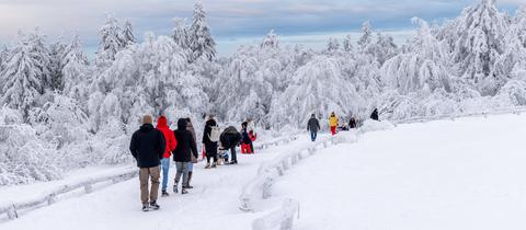 Ausflügler in tief winterlich verschneitem Wald am Großen Feldberg im Taunus