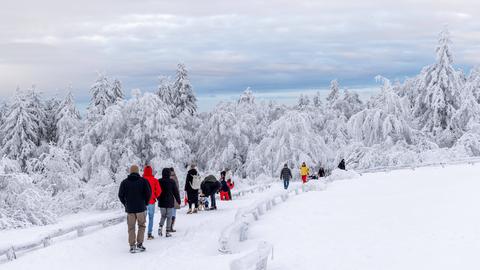Ausflügler in tief winterlich verschneitem Wald am Großen Feldberg im Taunus