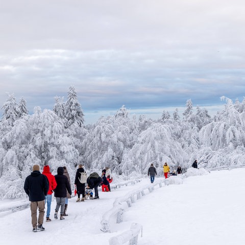 Ausflügler in tief winterlich verschneitem Wald am Großen Feldberg im Taunus