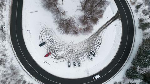 Drohnenaufnahme von Autospuren im Schnee