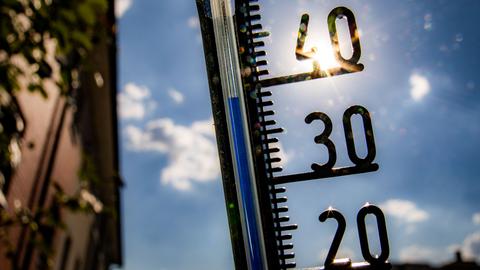 Ein Thermometer an einer Hauswand zeigt Temparaturen in Richtung der 40-Grad-Marke an.