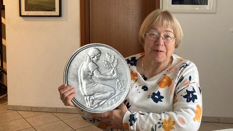 Tochter von Gerda "Jo" Werner, Monika Stehr, mit einer überdimensionalen, Essteller-großen 50-Pfennig-Münze