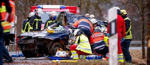 Wrack eines Autos nach einem Unfall und Rettungskräfte