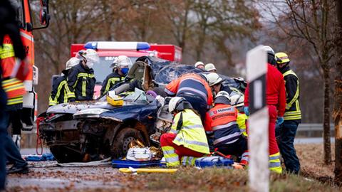 Wrack eines Autos nach einem Unfall und Rettungskräfte