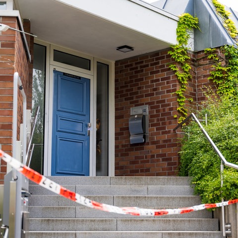 Haus mit Polizeiabsperrband und Versiegelung der Tür