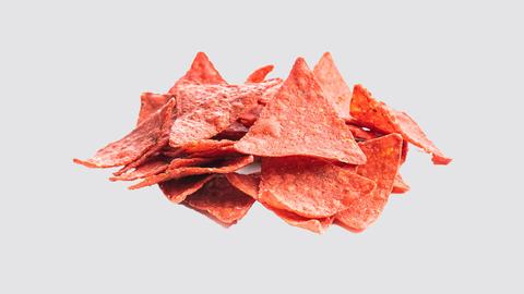 Rote Tortilla-Chips vor weißem Hintergrund.