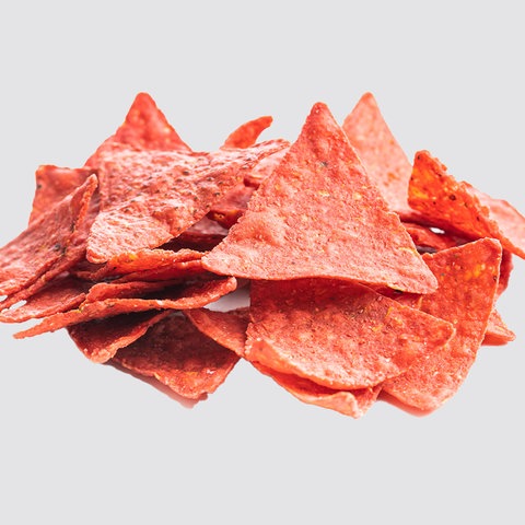 Rote Tortilla-Chips vor hellgrauem Hintergrund.