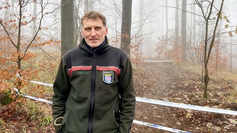 Ein Mitarbeiter des Forstes, Matthias Schnücker, steht im Wald und schaut in die Kamera.