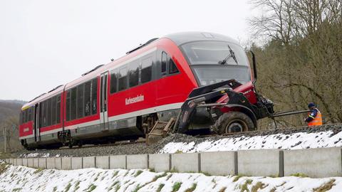 Zu sehen ist das Fahrerhaus eines Regionalzuges, vorne daran klemmt ein kleiner Traktor