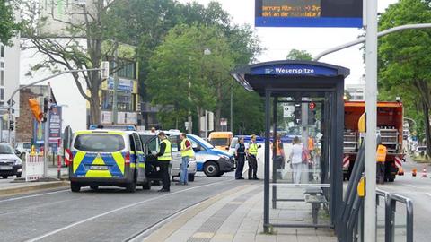 Mehrere Polizeiautos und Polizisten stehen an einer abgesperrten Straßenbahnhaltestelle.