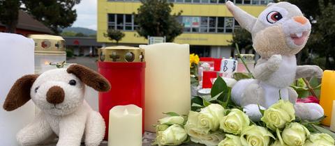 Kerzen und Blumen stehen vor der Schule in Bad Emstal. 