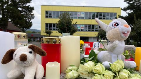 Kerzen und Blumen stehen vor der Schule in Bad Emstal. 