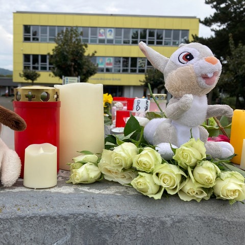 Kerzen und Blumen stehen vor der Schule in Bad Emstal. 