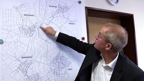 Gründaus Bürgermeister Gerald Helfrich zeigt das Wassernetz auf einer Karte.