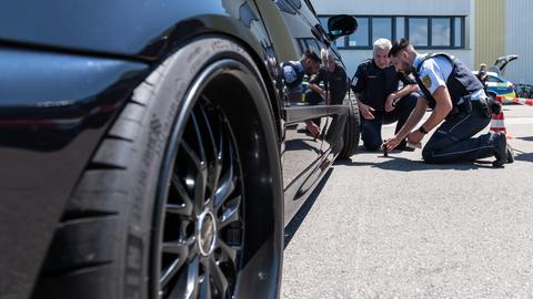 Zwei Polizeibeamte kontrollieren einen BMW