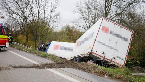 Ein Lkw samt Anhänger liegt im Straßengraben. 