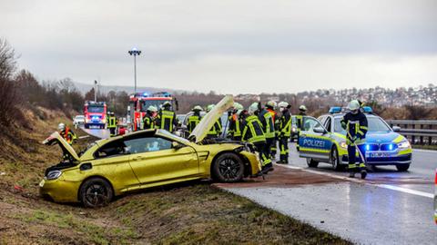 Ein gelbes Auto steht nach einem Unfall im Graben neben einer Autobahn.