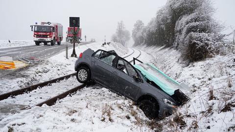 Auto liegt auf Schienen, dahinter ein Feuerwehrauto