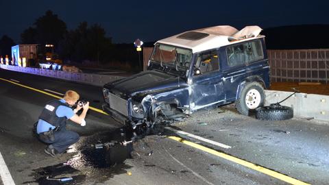Ein Polizist fotografiert einen beschädigten Geländewagen nach einem Unfall.