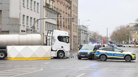 Das Bild zeigt eine Unfallstelle in der Darmstädter Innenstadt. Zu sehen sind zwei Polizeiautos, ein Lkw und ein Fahrrad