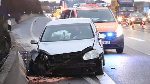 Ein beschädigtes Auto, dahinter ein Notarztwagen. 