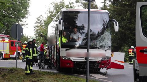 Ein durch einen Unfall beschädigter Reisebus, daneben stehen Rettungskräfte.