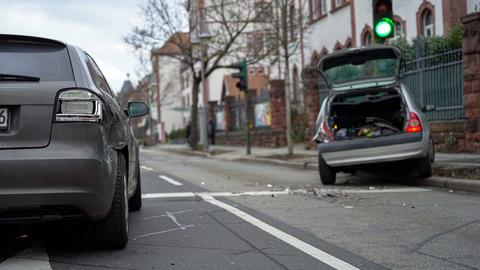 Zwei verunfallte Autos stehen auf einer Straße.