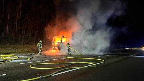 Feuerwehrleute löschen brennenden Lkw