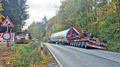 Schwertransporter mit dem Rumpf eines Windrads beladen, ist in den Graben an einem Waldrand gefahren