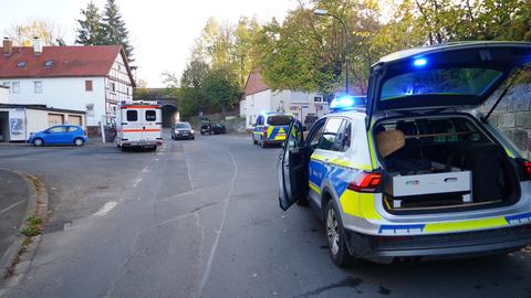Mehrere Polizeiautos und Rettungswagen stehen auf einer Straße vor einer Kindertagesstätte.