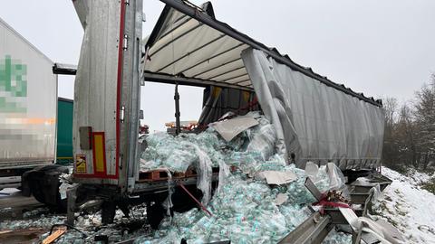 Wasserflaschen fallen von der Ladefläche eines kaputten Lastwagens