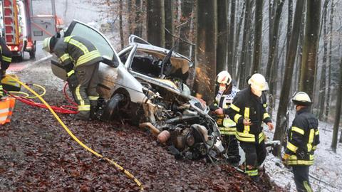 Feuerwehrleute an dem Unfallauto.