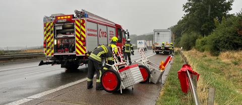 Ein Feuerwehrauto mit Einsatzkräften auf einer Autobahn.