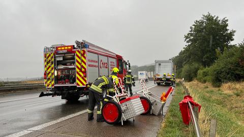 Ein Feuerwehrauto mit Einsatzkräften auf einer Autobahn.