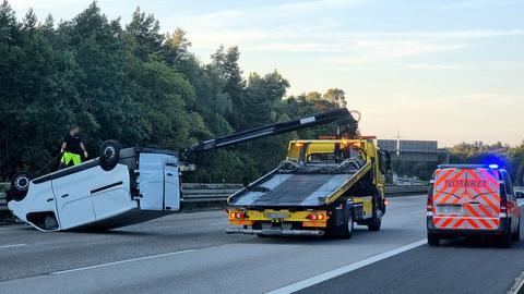 Der Transporter liegt auf der Seite auf der Fahrbahn, daneben ein Abschleppwagen. 