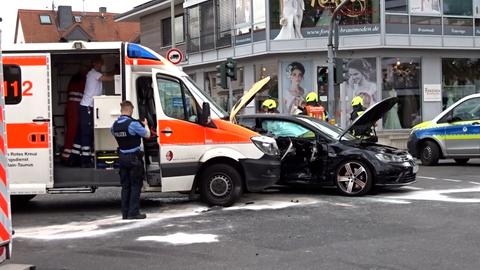 Ein beschädigter Rettungswagen an einer Kreuz, daneben ein beschädigtes Fahrzeug