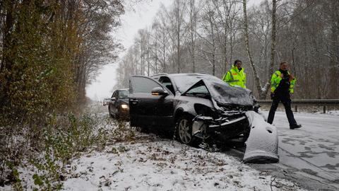 Autos stehen nach einem Unfall an der Seite einer verschneiten Straße.