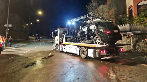 Abschlepper mit Unfallauto vor Mauer und Polizei-Absperrband