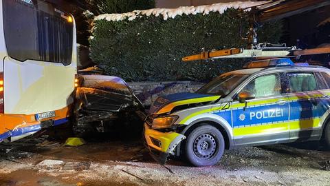 Der Fluchtwagen klemmt völlig zerbeult zwischen einem Linienbus und einem Polizeiauto.