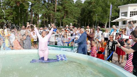 Frau im Schwimmbad, Menschen um sie herum