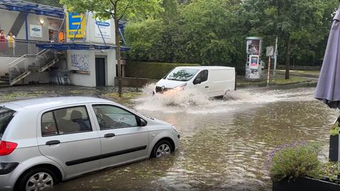 Autos in Kassel fahren auf überfluteter Straße