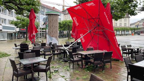 Umgekippter Sonnenschirm vor einem Café