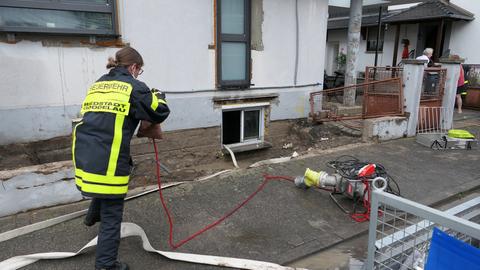 Eine Feuerwehrfrau pumpt einen durch das Unwetter vollgelaufenen Keller in Riedstadt-Goddelau aus.